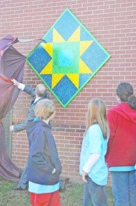 O.P. Earle Elementary Principal Brian Murray unveils the first of two quilt blocks outside the school. The blocks were painted by students. (photo by Samantha Hurst) 