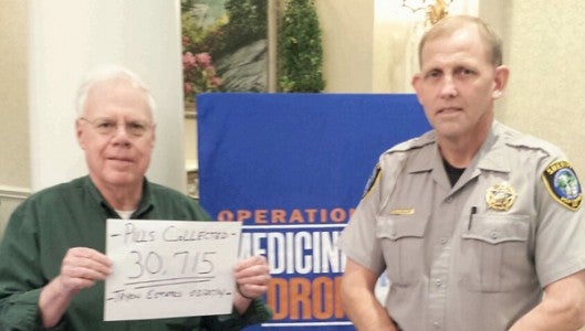 Polk County Sheriff Donald Hill (at right) stands with Tryon Estates resident Ralph Collins who is holding a sign saying Tryon Estates collected 30,715 unwanted pills during an Operation Medicine Drop on March 22. Collins arranged the medicine drop at Tryon Estates with local law enforcement having several locations throughout the county to drop off unwanted medications. In total, 56,976 pills were collected. (photo submitted by the Polk County Sheriff’s Office)