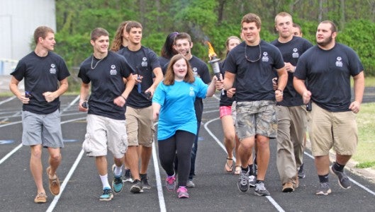  Polk County High School student volunteers and athletes bring in the torch during the opening ceremonies.   