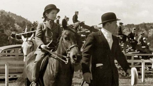 Lee Cowan, a major figure on the equestrian scene in Tryon during the first part of the 20th century, leads a young rider at the 1937 Tryon Horse & Hound Show.