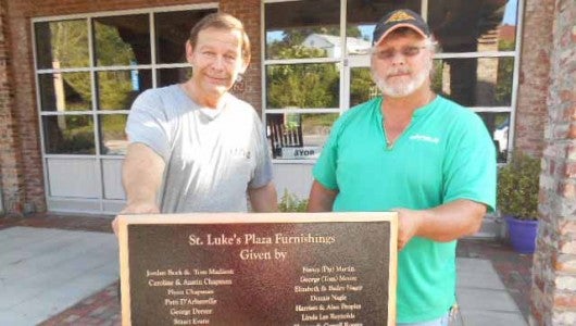 Crys Armbrust and Garfield installer Robbie Smith readying the plaque for mounting. 