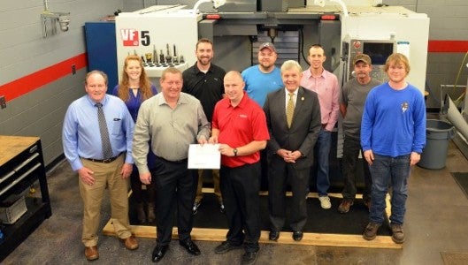 Kip Asmuth of Haas CNC presents a $25,000 check to Jeff Waters, the Machining Technologies instructor at Isothermal Community College. Looking on at the presentation were Isothermal’s president, Walter Dalton, Dean Joe Looney of Applied Sciences and Engineering Technologies, grant writer Sarah Morse and several machining technologies students.