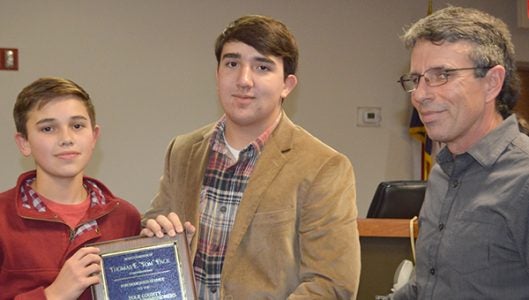 The Polk County Board of Commissioners recognized Tom Pack, who was commissioner chair when he passed away in March this year by presenting a plaque to Pack’s two sons, Eric and Timothy during the county’s Dec. 5 meeting. Pictured is Timothy and Eric Pack with outgoing commissioner chair Michael Gage.