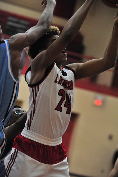 Landrum's Manny Gonzalez (#24, right) has provided excellent rebounding help for Landrum's men's varsity this season. Gonzalez has his eyes on this offensive rebound in Tuesday’s game against Christ Church Episcopal, which Landrum won, 69-61.